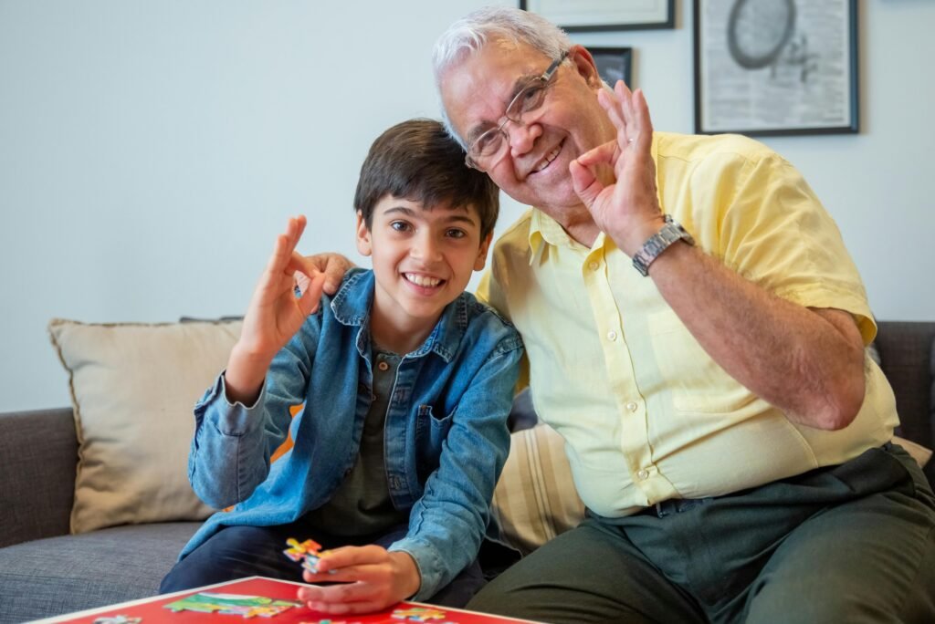 A joyful moment between grandfather and grandson engaged in a jigsaw puzzle at home.